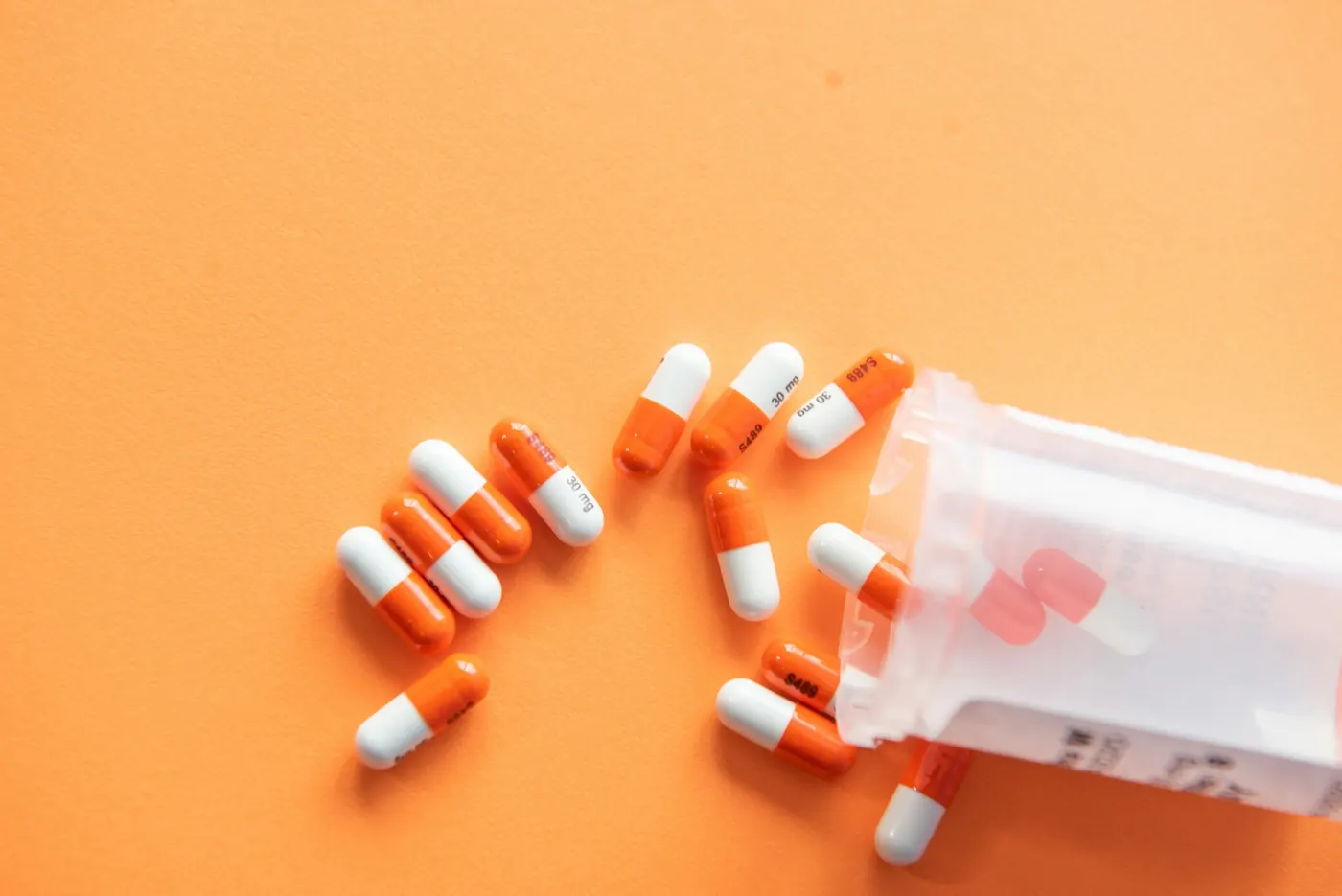 Orange and white capsules on an orange background